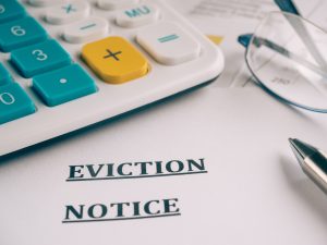 eviction notice next to a calculator and glasses