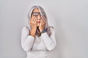 Stressed woman rubbing eyes and tired 